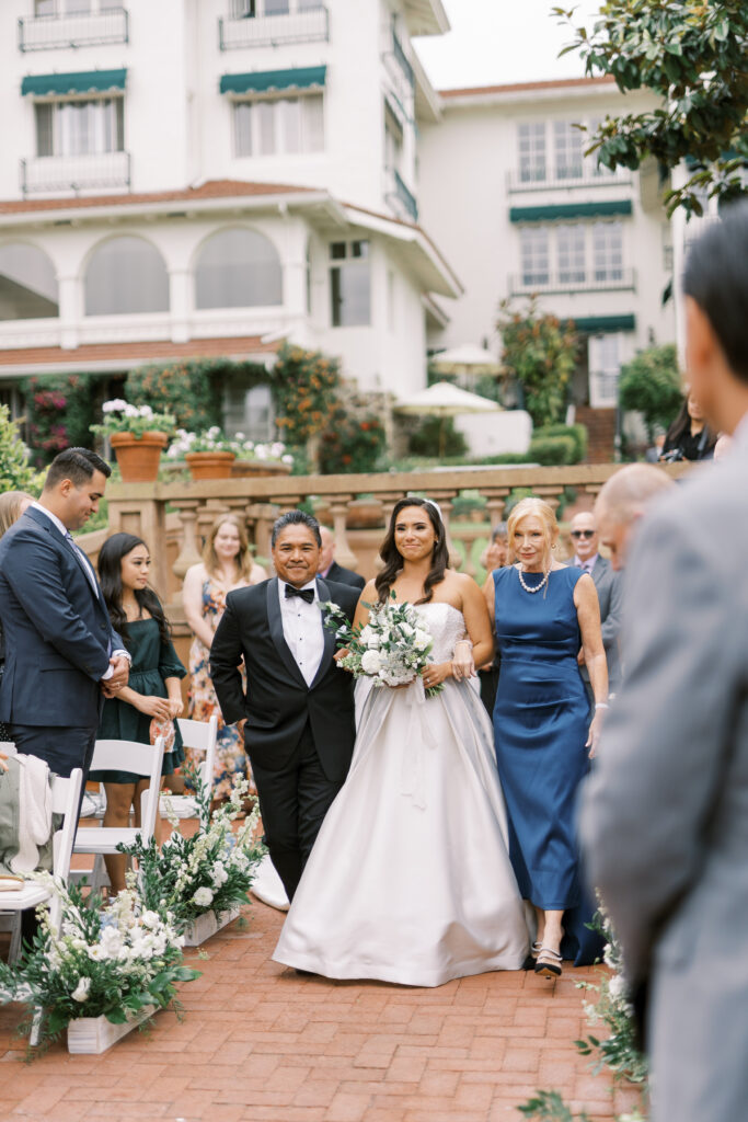 bride walking down the aisle with parents