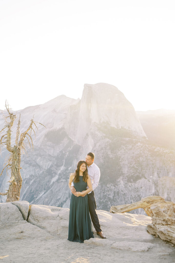 Newly engaged couple standing on a hilltop