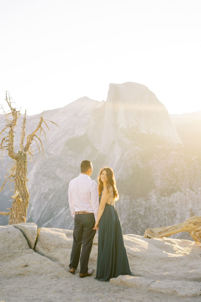 Couple standing on a hilltop with a stunning sunset sky