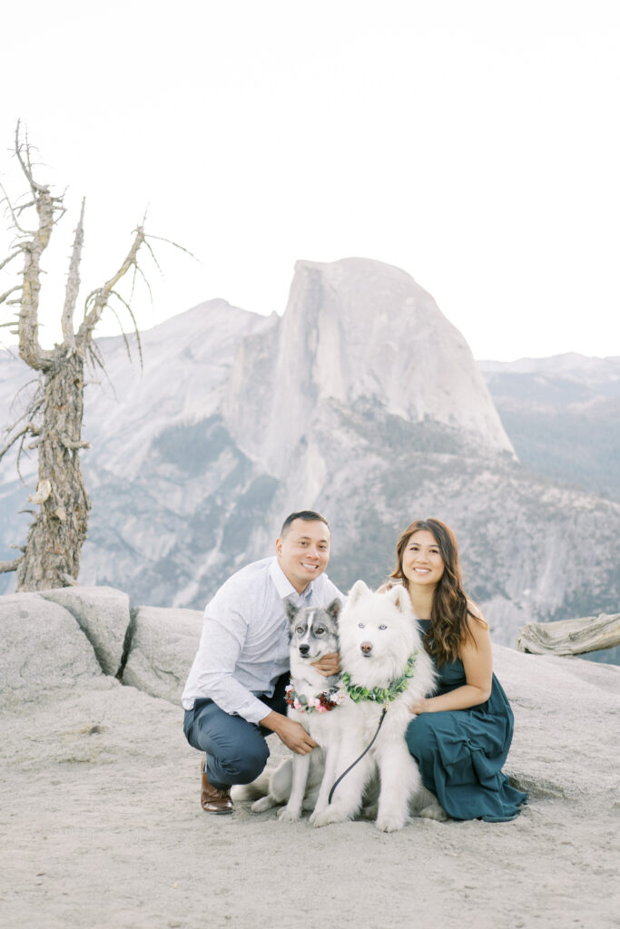 Couple posing for a picture on a cliffside with dog