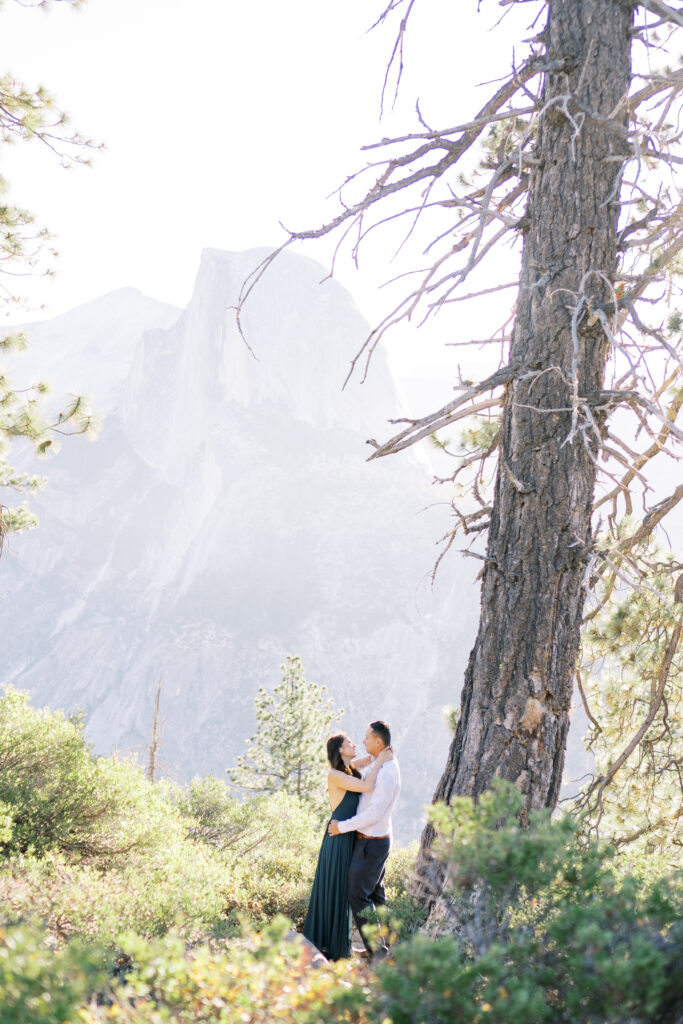 Couple standing on a cliff in Yosemite with sunlight