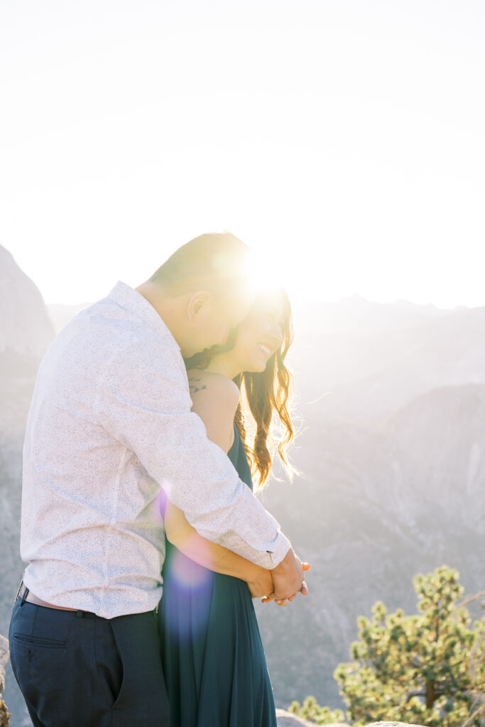 Intimate portrait of newly engaged couple against the sun