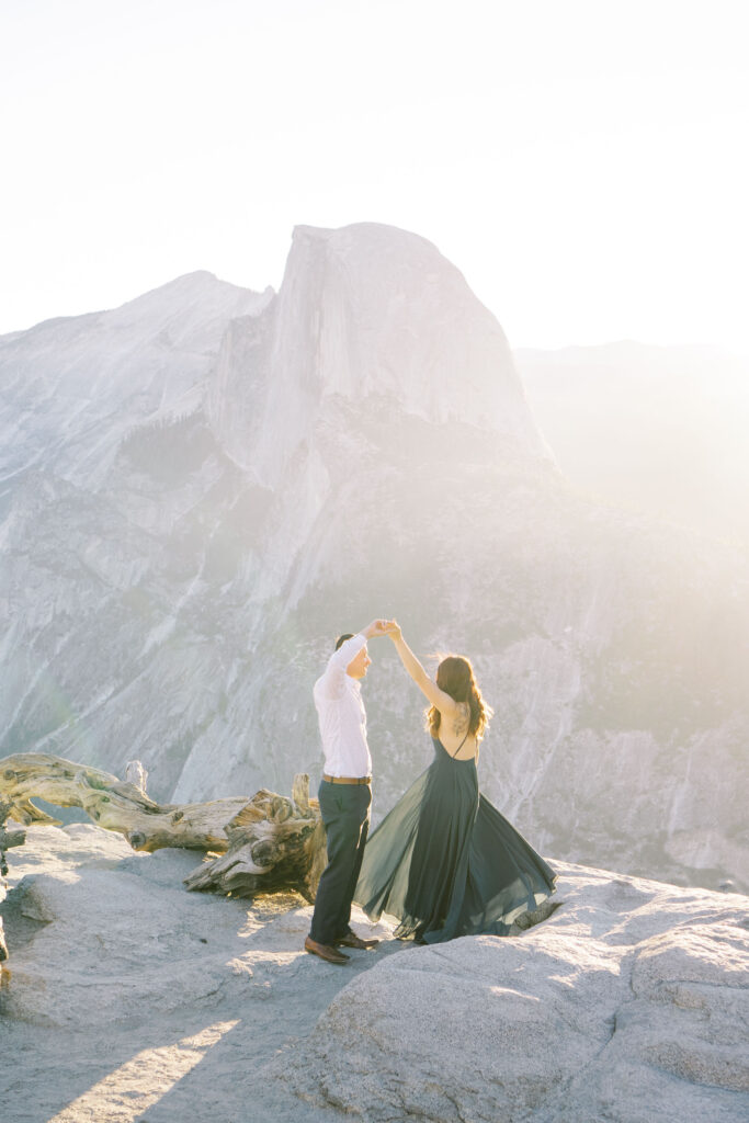 Joyful engaged couple sharing a dance in the sun at yosemite