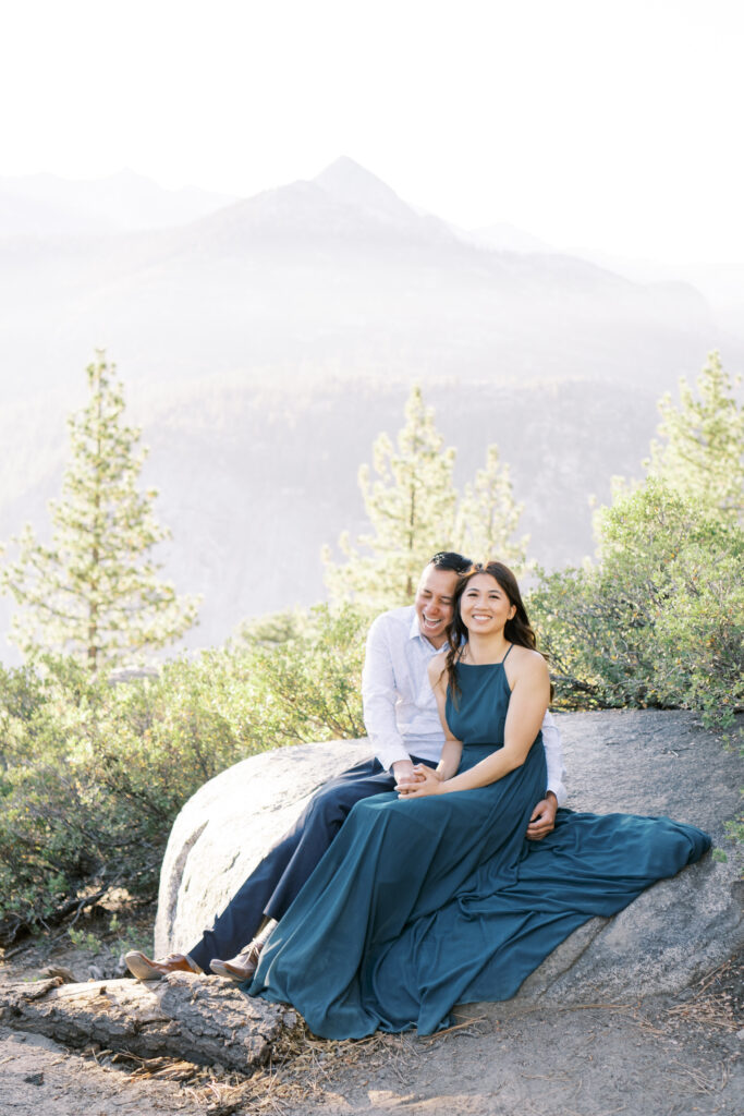 Couple sitting happily with Yosemite on the background