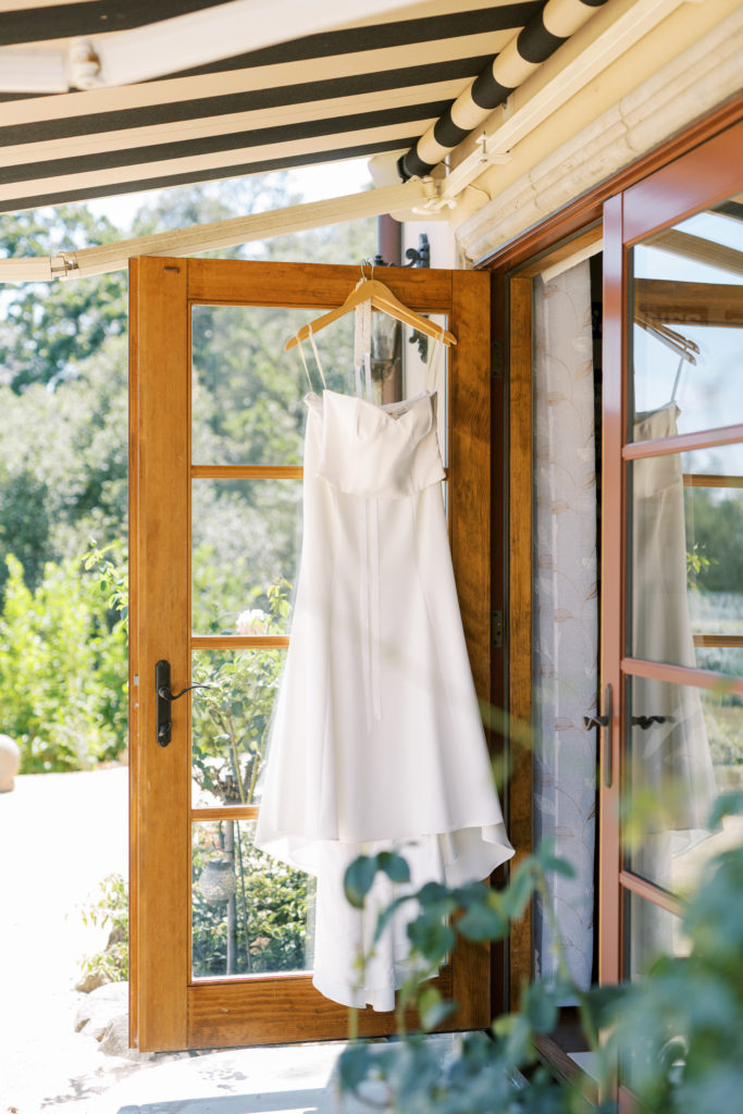 bride's dress hanging at the door