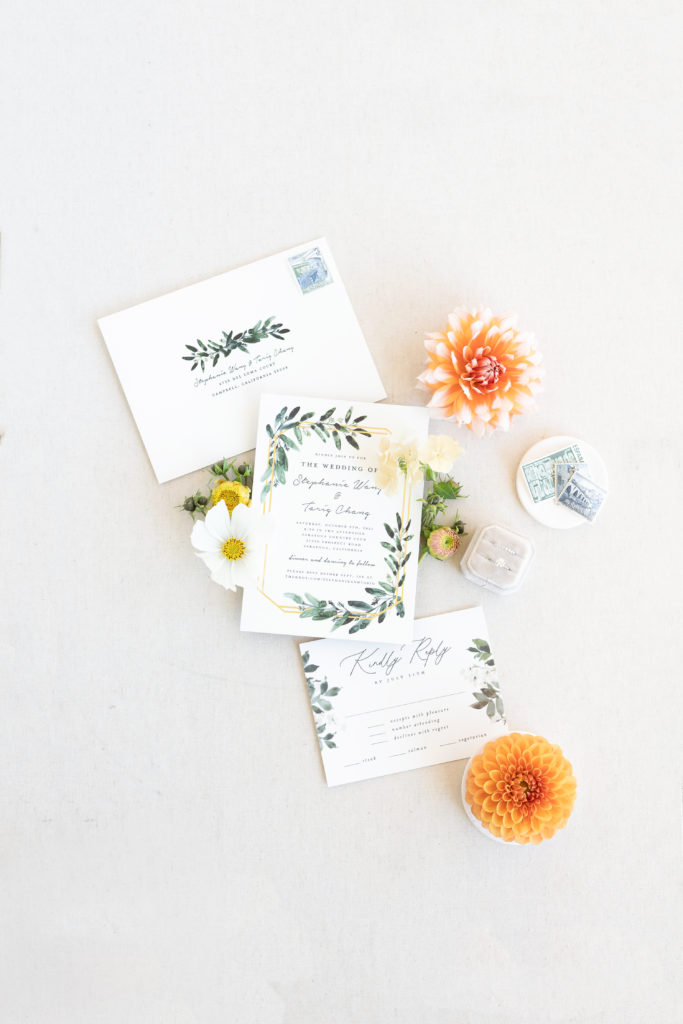 invitation flat lay with green and gold palette