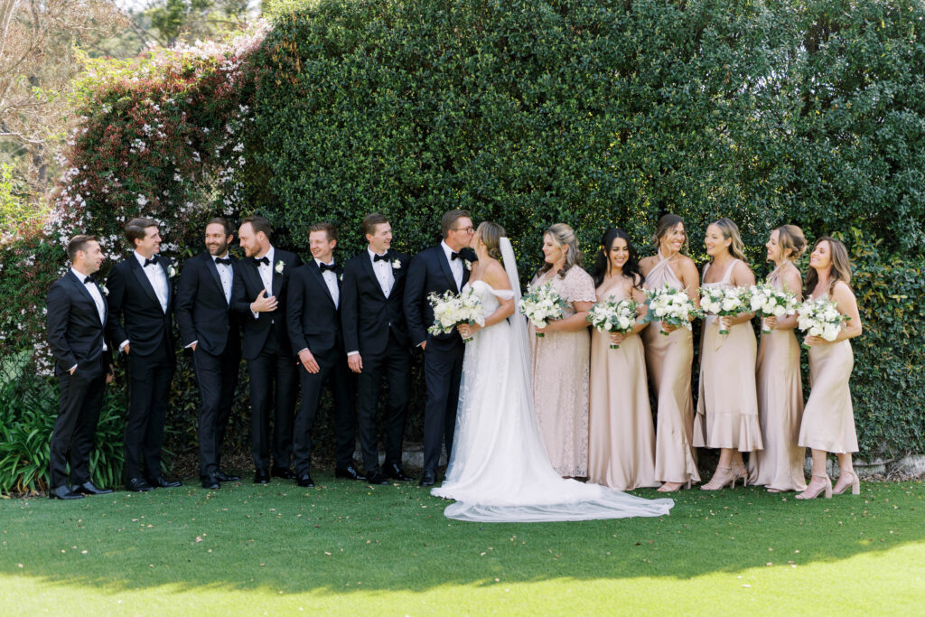 bridesman and groomswoman photo with bride and groom kissing