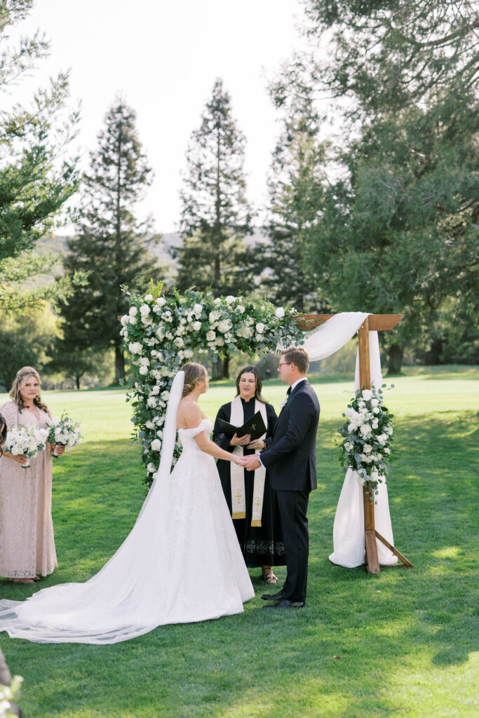 bride and groom in front of wedding officiant