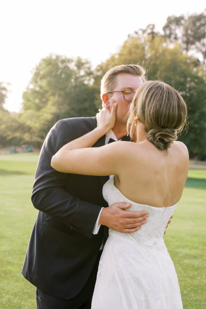 bride and groom kissing during golden hour