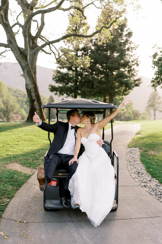 bride and groom kissing on golf car