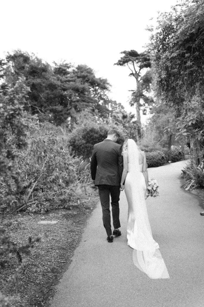 bride and groom walking down aisle together black and white shoot