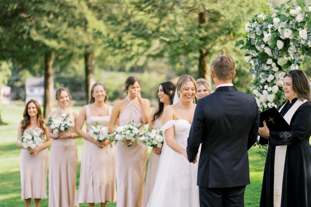 bride laughing in front of wedding officiant