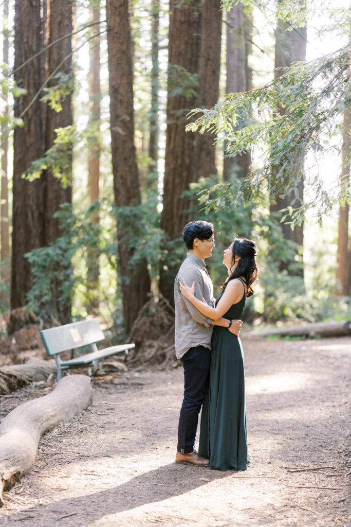 couple hugging and looking at each other in the middle of the forest