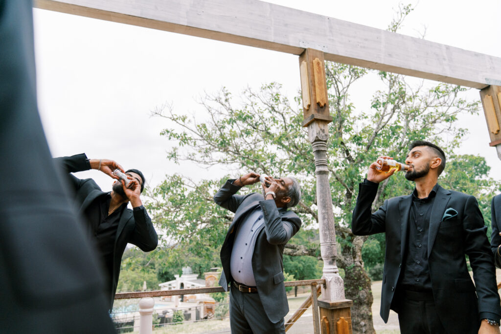 A trio of men chugging their drinks