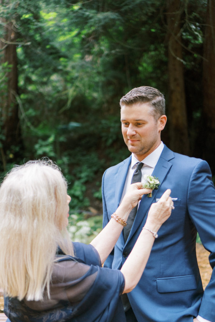mom giving boutonniere to groom
