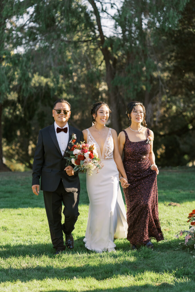 bride walking down the aisle with parents