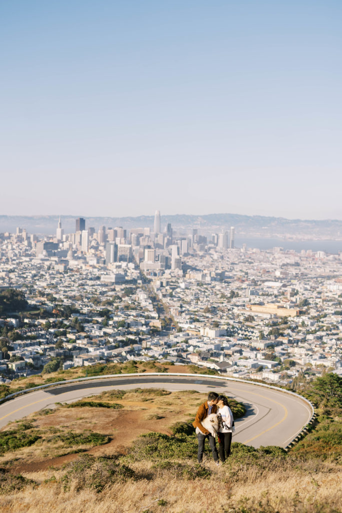 Engaged couple kissing over the view of San Francisco