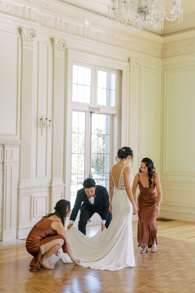 bridal party fixing up the dress