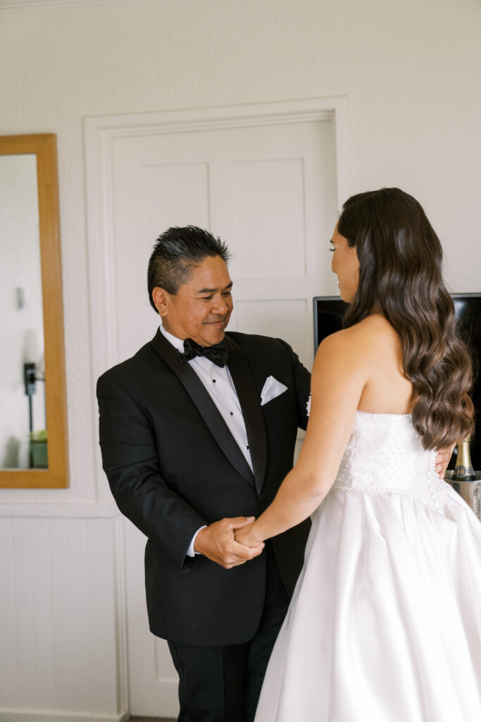 Bride's father examines his daughter fondly