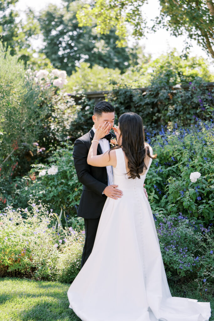 bride wiping groom's tears during first look