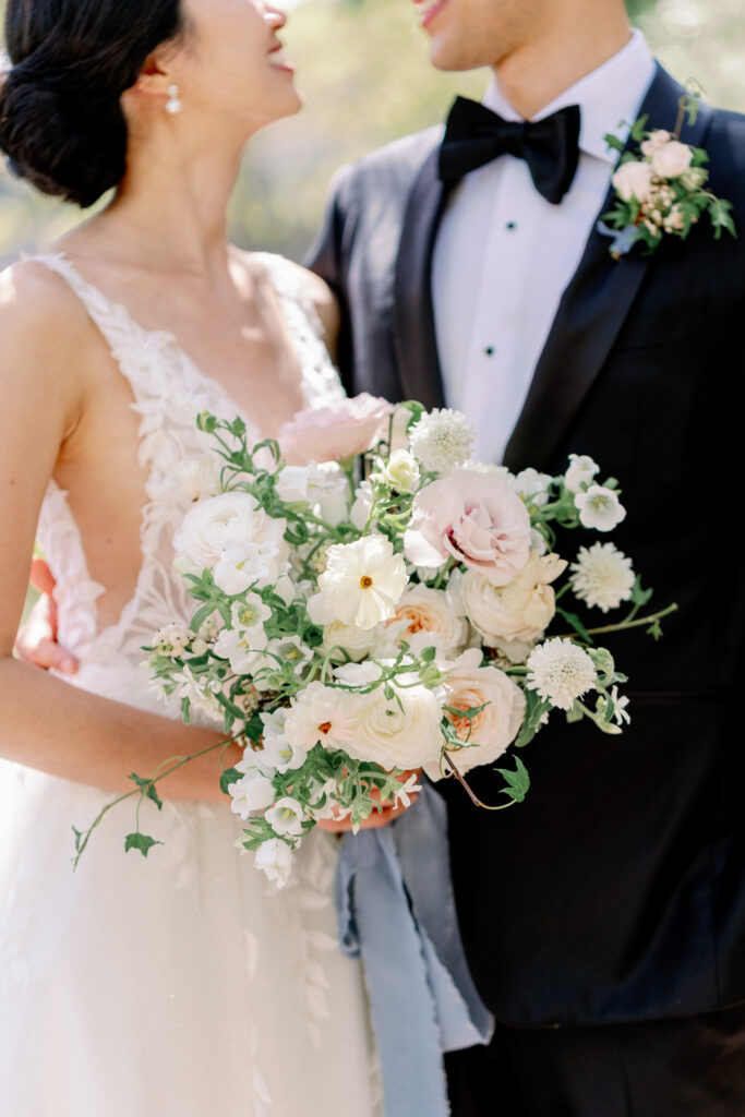 close up photo of bridal bouquet with bride and groom behind the photo