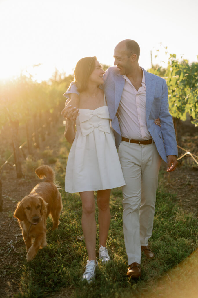 grooms arm over brides shoulder walking together in vineyard