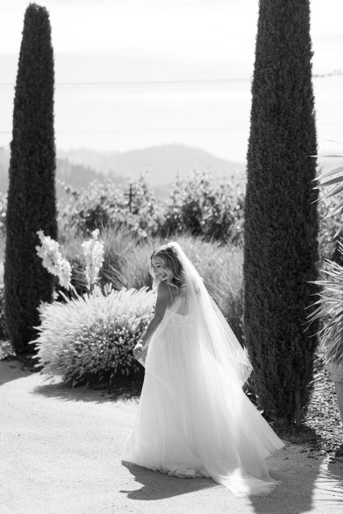 bride walking showing off back details of gown. photo in black and white