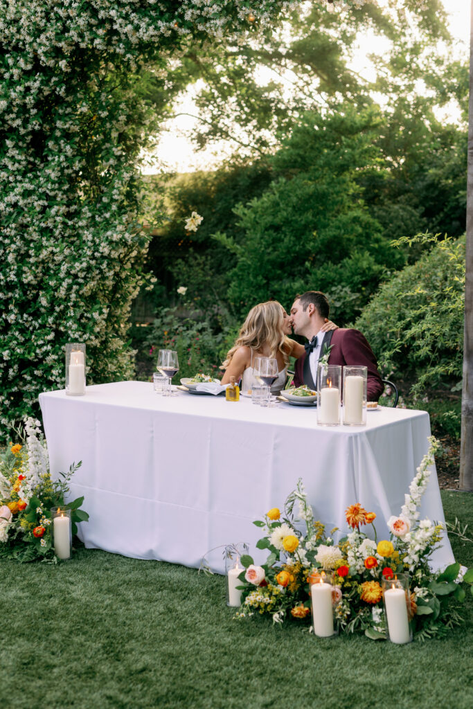 bride and groom kissing at the couple's table at the reception