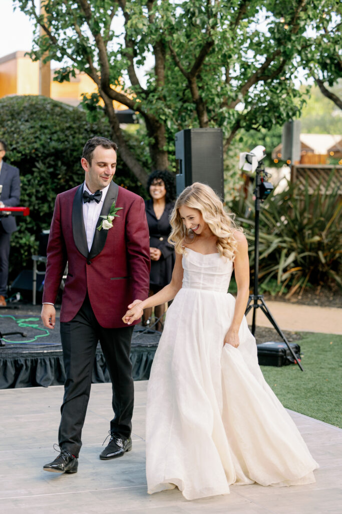bride and groom holding hands at the dance floor