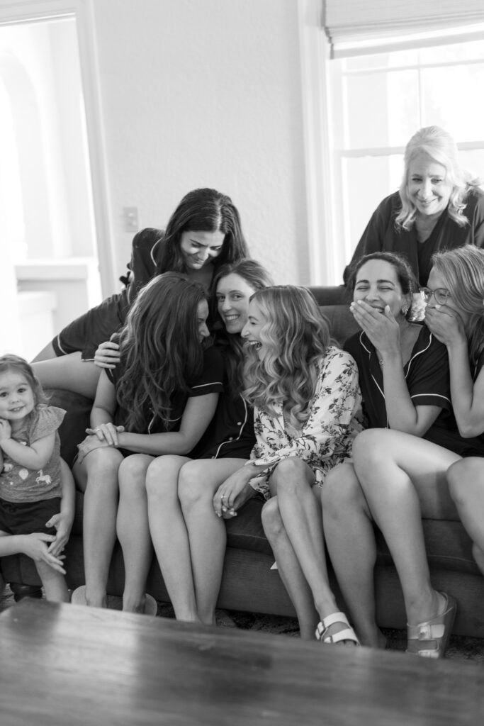 black and white candid photo of bride and bridesmaids laughing