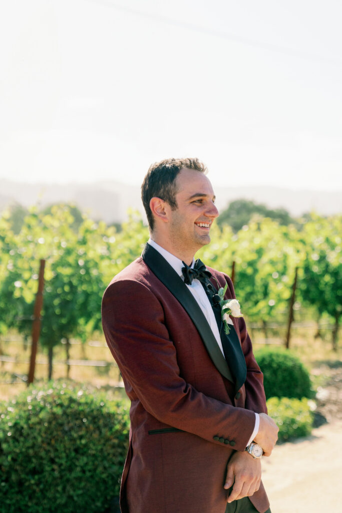 candid photo of groom waiting while smiling