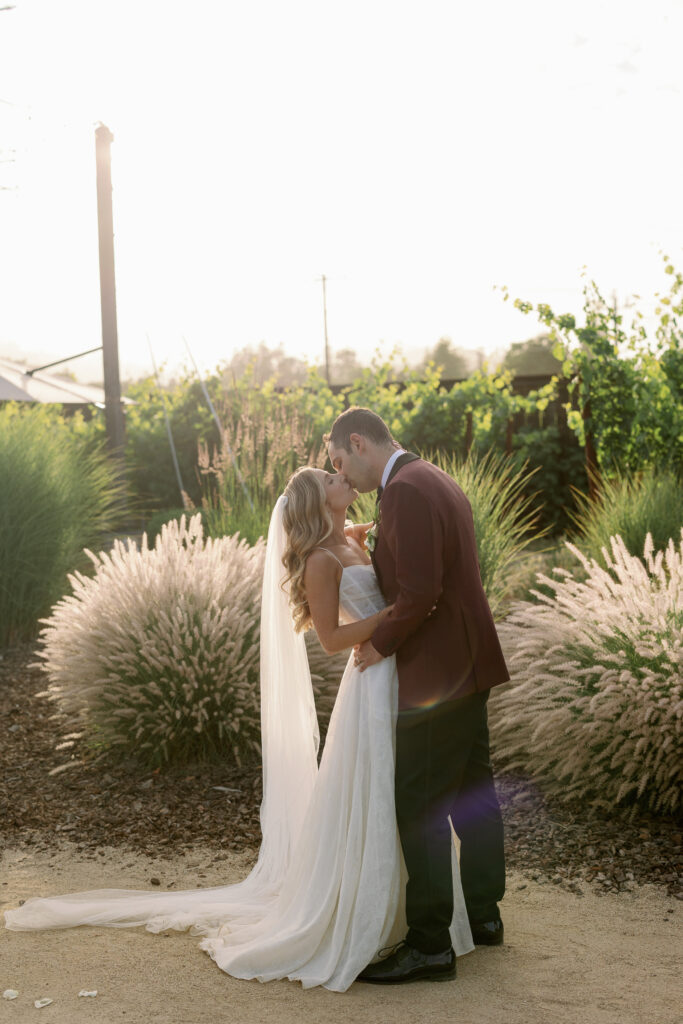 bride and groom kissing during outdoor photoshoot