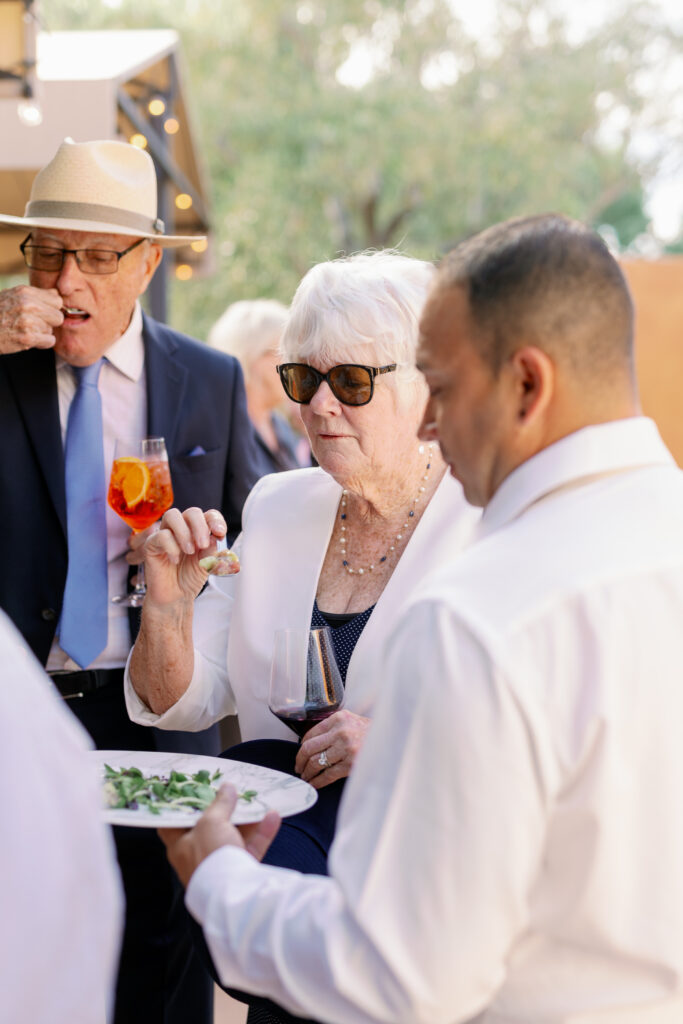 wedding guests at the reception trying finger foods