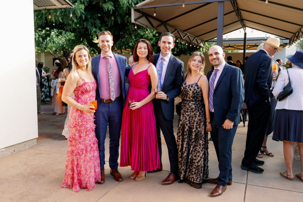 wedding guests in colorful dresses posing for a picture